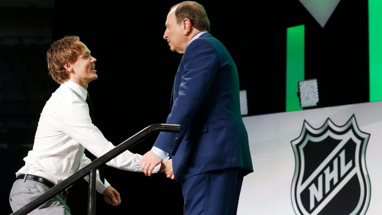 Filip Johansson, left, of Sweden, is greeted by NHL Commissioner Gary Bettman after being selected by the Minnesota Wild during the NHL hockey draft in Dallas, Friday, June 22, 2018. (Michael Ainsworth/AP)