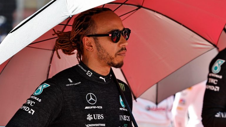 Mercedes driver Lewis Hamilton of Britain holds an umbrella prior to the start of the Azerbaijan Formula One Grand Prix at the Baku circuit, in Baku, Azerbaijan, Sunday, June 12, 2022. (Hamad Mohammed, Pool Via AP)