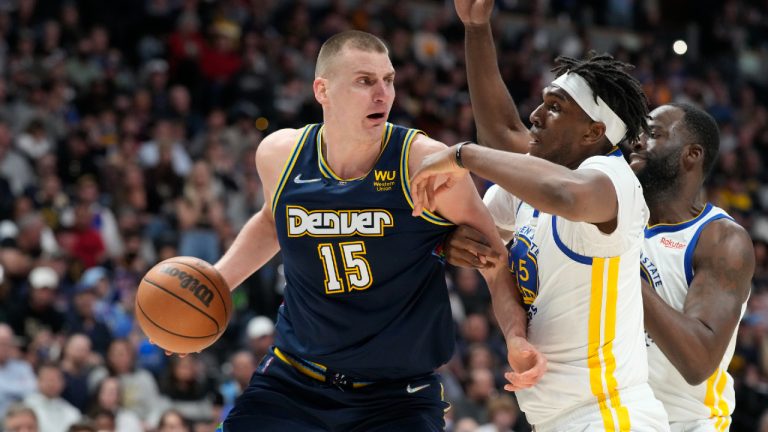 Denver Nuggets center Nikola Jokic, left, looks to pass the ball as Golden State Warriors center Kevon Looney, center, and forward Draymond Green defend in the second half of Game 4 of an NBA basketball first-round Western Conference playoff series Sunday, April 24, 2022, in Denver. (David Zalubowski/AP)