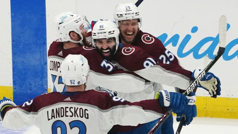 Colorado Avalanche center Nazem Kadri (91) is congratulated by teammates after his overtime goal on Tampa Bay Lightning goaltender Andrei Vasilevskiy (88) in Game 4 of the NHL hockey Stanley Cup Finals on Wednesday, June 22, 2022, in Tampa, Fla. (John Bazemore/AP)