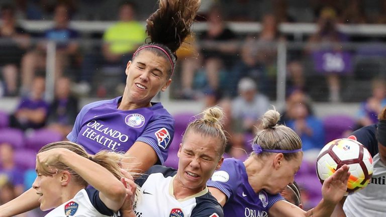 FILE - In this June 30, 2018, file photo, several players collide as Orlando Pride's Alex Morgan, top left, heads the ball toward the net during an NWSL soccer game against the North Carolina Courage at Orlando City Stadium in Orlando, Fla. (Stephen M. Dowell/Orlando Sentinel via AP, File)