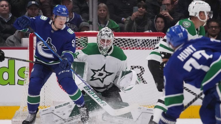 Dallas Stars goalie Jake Oettinger, second right, makes the save as Vancouver Canucks' Sheldon Dries tries to redirect the puck during the first period of an NHL hockey game in Vancouver, B.C., Monday, April 18, 2022. (Darryl Dyck/CP)