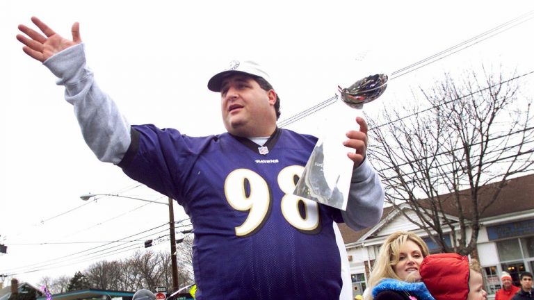 FILE - Tony Siragusa, defensive tackle for the Super Bowl-champion Baltimore Ravens, holds the Vince Lombardi trophy as he rides with his wife, Kathy, in a parade in his hometown of Kenilworth, N.J. on March 4, 2001. Siragusa, the charismatic defensive tackle who helped lead a stout Baltimore defense to a Super Bowl title, has died at age 55. Siragusa's broadcast agent, Jim Ornstein, confirmed the death Wednesday, June 22, 2022. (Jeff Zelevansky/AP)