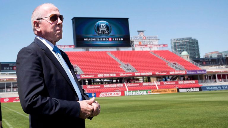 Larry Tanenbaum, right, MLSE chairman, walks on to BMO Field following a press conference in Toronto. (Darren Calabrese/CP)