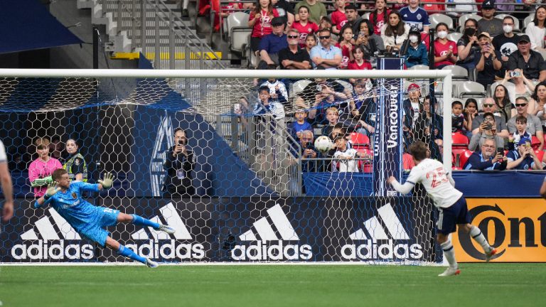 Vancouver Whitecaps' Ryan Gauld, right, scores on a penalty kick against Real Salt Lake goalkeeper Zac MacMath during the second half of an MLS soccer game in Vancouver, on Saturday, June 4, 2022. (Darryl Dyck/CP)