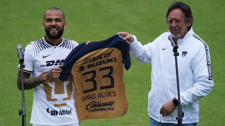 Brazilian Dani Alves receives his official Pumas' jersey from club president Leopoldo Silva, during his presentation as a new member of the Pumas UNAM soccer club, on the pitch at the Pumas training facility in Mexico City, Saturday, July 23, 2022. (Marco Ugarte/AP)