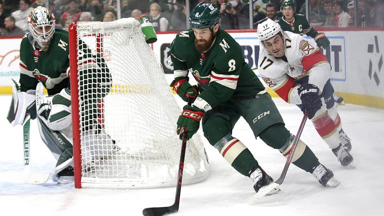 Minnesota Wild defenseman Jordie Benn (8) controls the puck in front of Florida Panthers left wing Mason Marchment (17) while Wild goaltender Cam Talbot  watches during the second period of an NHL hockey game. (Andy Clayton-King/AP)