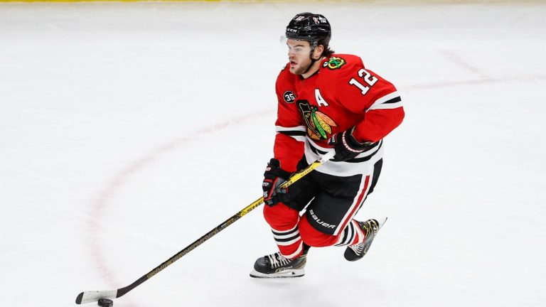 Chicago Blackhawks left wing Alex DeBrincat (12) looks to pass the puck against the Calgary Flames during the first period of an NHL hockey game. (Kamil Krzaczynski/AP)