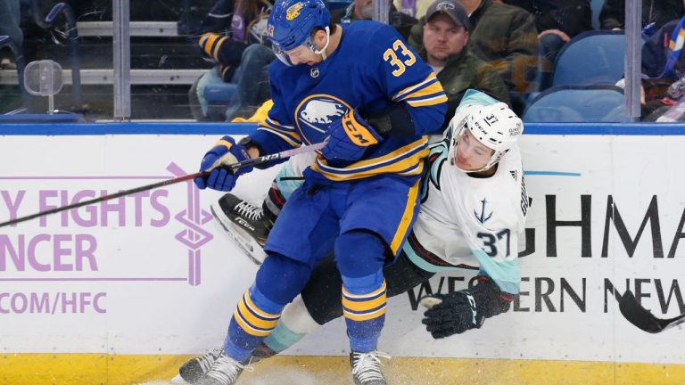 Seattle Kraken centre Yanni Gourde (37) is checked by Buffalo Sabres defenceman Colin Miller (33) during the 2021-22 NHL season. (Jeffrey T. Barnes/AP)