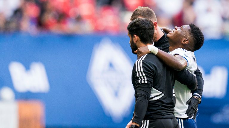 Vancouver Whitecaps' Déiber Caicedo, right, reacts as he his helped off the field by the medical staff after getting injured during first half MLS soccer action against the New England Revolution in Vancouver, B.C., Sunday, June 26, 2022. Rich Lam/CP