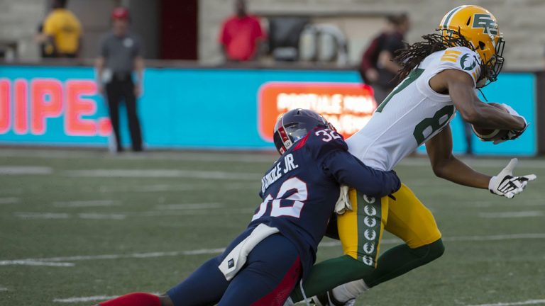 Montreal Alouettes' Rodney Randle Jr. tackles Edmonton Elks' Derel Walker during frist half CFL action in Montreal on Thursday July 14, 2022. (Peter McCabe/CP)