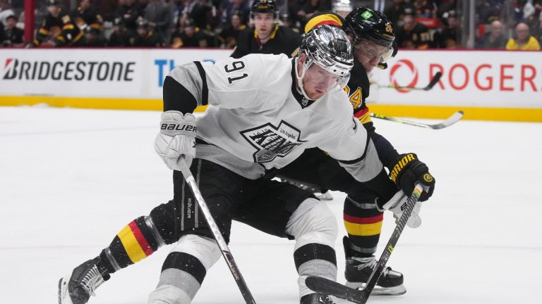 Vancouver Canucks' Travis Dermott, back, checks Los Angeles Kings' Carl Grundstrom during third period NHL hockey action in Vancouver on Thursday, April 28, 2022. (Darryl Dyck/THE CANADIAN PRESS)