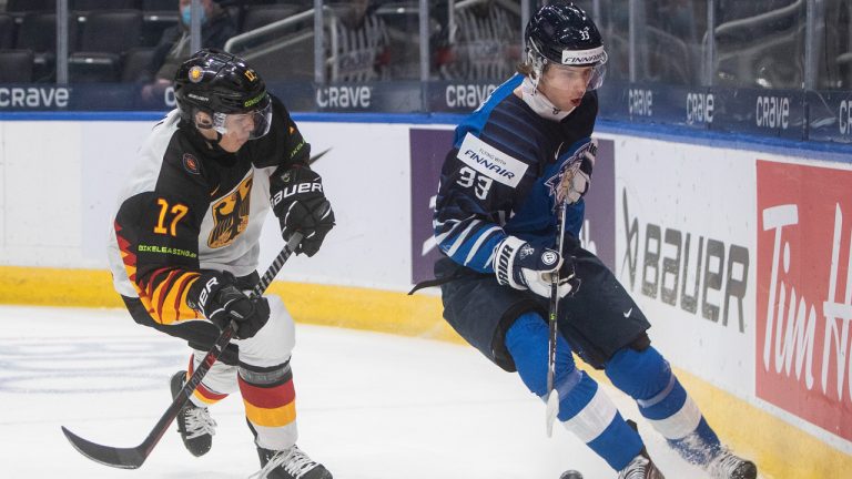 Finland's Brad Lambert (33) is chased by Germany's Fabrizio Pilu (17) during first period IIHF World Junior Hockey Championship action in Edmonton, Sunday, Dec. 26, 2021. (Jason Franson/CP)