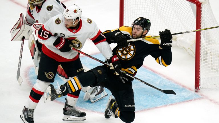 Ottawa Senators defenseman Michael Del Zotto (15) clears Boston Bruins left wing Jake DeBrusk away from the crease during the third period of an NHL hockey game Thursday, April 14, 2022, in Boston. (Charles Krupa/AP)