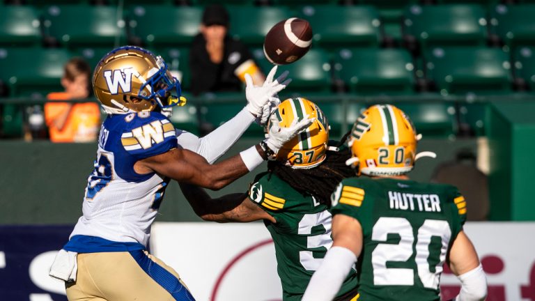 Winnipeg Blue Bombers Rasheed Bailey (88) makes the catch as Edmonton Elks Treston Decoud (37) and Scott Hutter (20) try to stop him during first half CFL action in Edmonton, Alta., on Friday July 22, 2022. (Jason Franson/CP)