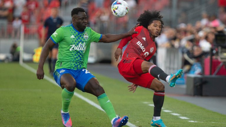 Toronto FC forward Jayden Nelson (right) flicks the ball over the head of Seattle Sounders defender Yeimar Gómez during first half MLS action in Toronto on Saturday July 2, 2022. (Chris Young/CP)