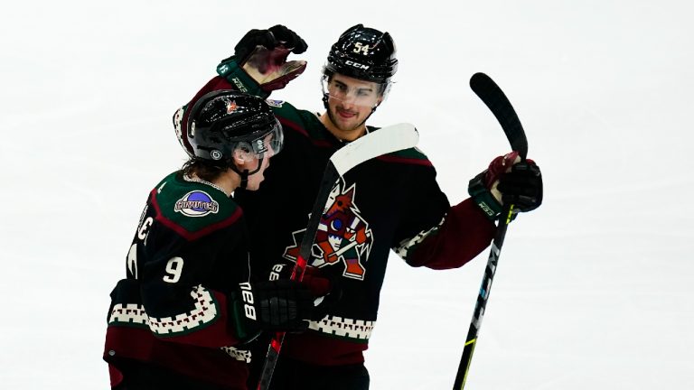 Arizona Coyotes right wing Clayton Keller (9) celebrates his goal against the Chicago Blackhawks with defenseman Cam Dineen (54) during the third period of an NHL hockey game Thursday, Jan. 6, 2022, in Glendale, Ariz. The Coyotes won 6-4. (Ross D. Franklin/AP)