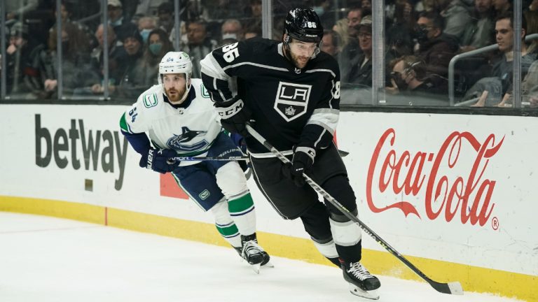 Los Angeles Kings' Christian Wolanin moves the puck as he is followed by Vancouver Canucks' Tyler Motte during first period of an NHL hockey game Thursday, Dec. 30, 2021, in Los Angeles. (Jae C. Hong/CP)