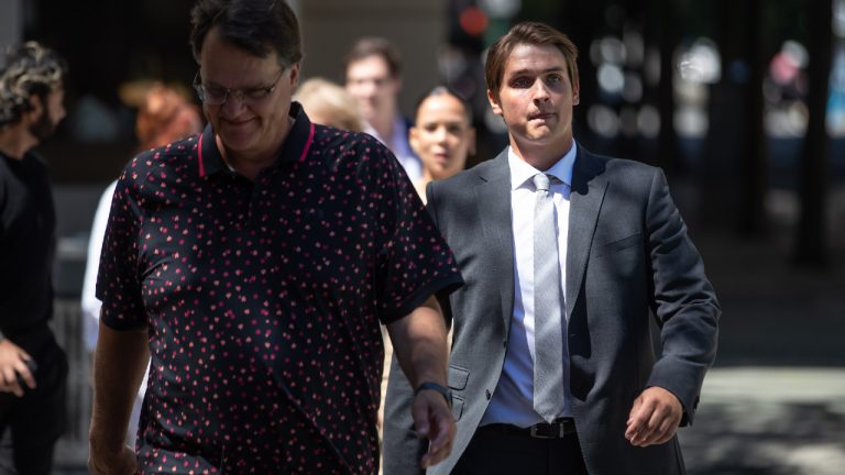 Former Vancouver Canucks NHL hockey player Jake Virtanen, right, returns to B.C. Supreme Court with his father Rainer after a lunch break in his sexual assault trial, in Vancouver, on Tuesday, July 19, 2022. (Darryl Dyck/CP)