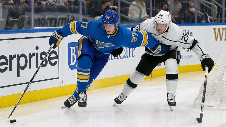 St. Louis Blues' Klim Kostin (37) handles the puck while under pressure from Los Angeles Kings' Sean Walker (26) during the second period of an NHL hockey game Saturday, Oct. 23, 2021, in St. Louis. (Scott Kane/AP)