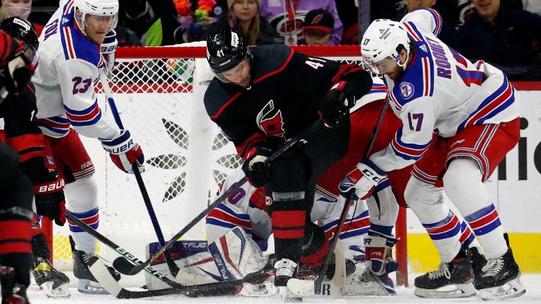 Carolina Hurricanes' Josh Leivo (41) battles for the puck between New York Rangers' Adam Fox (23) and Kevin Rooney (17) in front of Rangers goaltender Alexandar Georgiev during the first period of an NHL hockey game in Raleigh, N.C., Friday, Jan. 21, 2022. (Karl B DeBlaker/AP)