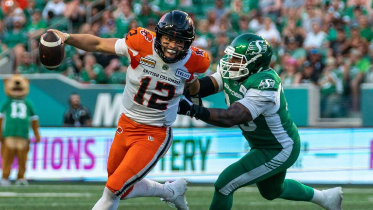 BC Lions quarterback Nathan Rourke (12) evades a tackle from Saskatchewan Roughriders defensive lineman Charleston Hughes (39) during the second quarter of CFL football action. (Heywood Yu/CP)