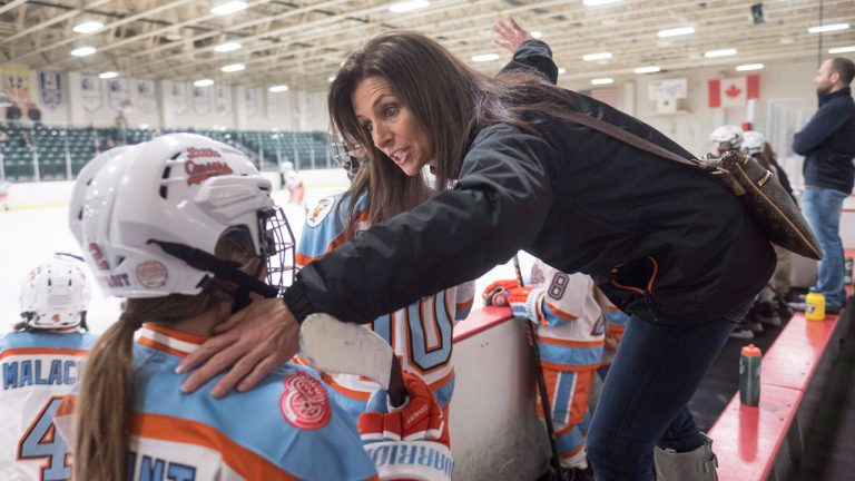 Former goaltender Manon Rheaume gives instructions to a player while behind the bench. (Paul Chiasson/CP)