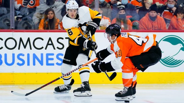 Pittsburgh Penguins' John Marino, left, passes the puck against Philadelphia Flyers' Morgan Frost during the third period of an NHL hockey game, Thursday, Jan. 6, 2022, in Philadelphia. (Matt Slocum/AP)