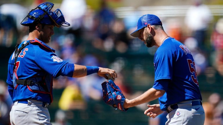 Chicago Cubs catcher Yan Gomes, left, gives a new baseball to relief pitcher Chris Martin during the third inning of a spring training baseball game against the Los Angeles Angels, Thursday, March 24, 2022, in Tempe, Ariz. (Ross D. Franklin/AP)