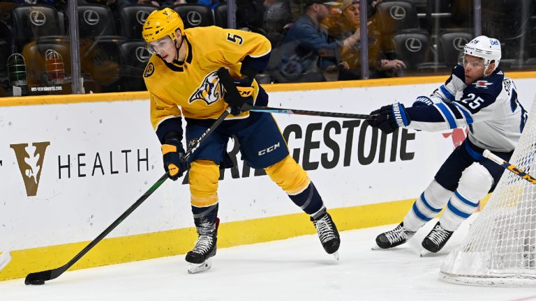 Nashville Predators defenseman Matt Benning (5) passes the puck as Winnipeg Jets center Paul Stastny (25) defends during the first period of an NHL hockey game Thursday, Jan. 20, 2022, in Nashville, Tenn. (Mark Zaleski/AP)