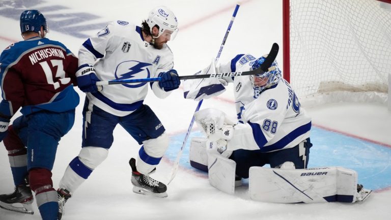 Tampa Bay Lightning goaltender Andrei Vasilevskiy, right, makes a glove against Colorado Avalanche right wing Valeri Nichushkin, left, as Lightning defenseman Ryan McDonagh watches during the third period of Game 5 of the NHL hockey Stanley Cup Final, Friday, June 24, 2022, in Denver. (David Zalubowski/AP)