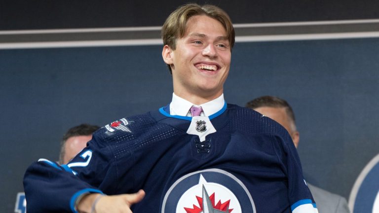 Rutger McGroarty puts on his Winnipeg Jets sweater after being selected during the 2022 NHL Draft in Montreal. (Ryan Remiorz/CP)