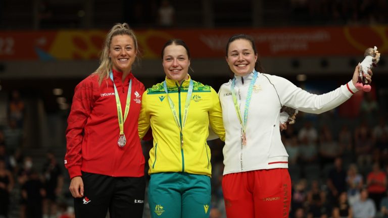 Kristina Clonan of Team Australia, center, Kelsey Mitchell of Team Canada, left, Sophie Capewell of Team England celebrate their gold, silver and bronze respectively for the women's 500-meters time trial during the Commonwealth Games track cycling at Lee Valley VeloPark in London, Sunday, July 31, 2022. (Ian Walton/AP)