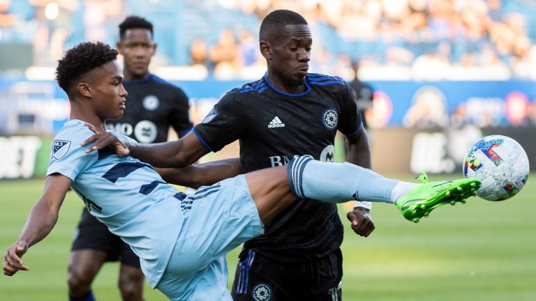 Sporting KC's Kayden Pierre, left, clears the ball from CF Montreal’' Jojea Kwizera during first half MLS soccer action in Montreal, Saturday, July 9, 2022. (Graham Hughes/CP)