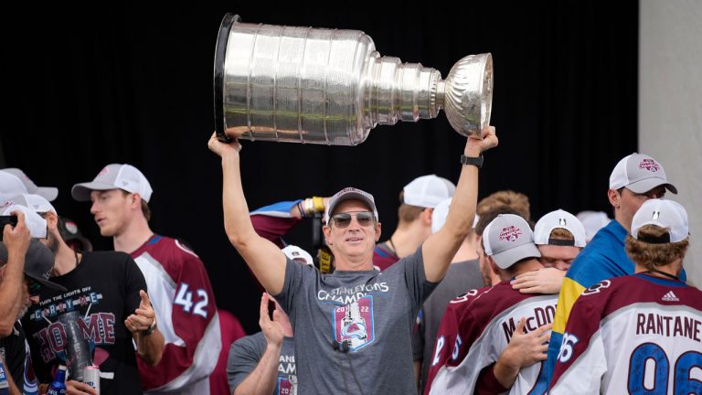 Colorado Avalanche general manager Joe Sakic lifts the Stanley Cup during a rally outside the City/County Building for the NHL hockey champions after a parade through the streets of downtown Denver. (David Zalubowski/AP)