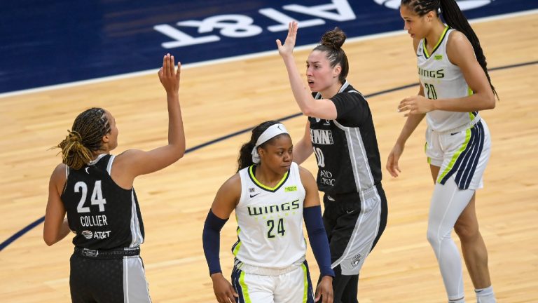 Minnesota Lynx forwards Napheesa Collier (24) and Jessica Shepard (10) high-five after forcing a turnover on a shot clock violation, as Dallas Wings guard Arike Ogunbowale (24) and forward Isabelle Harrison (20) react during the second half of a WNBA basketball game Wednesday, July 7, 2021, in Minneapolis. (Aaron Lavinsky/Star Tribune via AP)