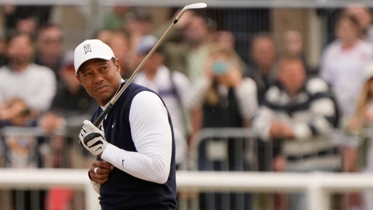 Tiger Woods of the US reacts to dust after playing a shot on the 1st hole during the first round of the British Open golf championship on the Old Course at St. Andrews, Scotland, Thursday, July 14 2022. (Gerald Herbert/AP)