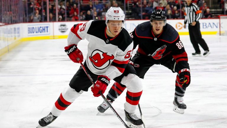 New Jersey Devils' Jesper Bratt (63), of Sweden, protects the puck from Carolina Hurricanes' Teuvo Teravainen (86), of Finland, during the first period of an NHL hockey game in Raleigh, N.C., Friday, Feb. 14, 2020. (Karl B DeBlaker/AP Photo)