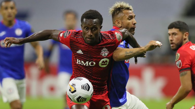 Richie Laryea of Canada's Toronto FC, front, and Walter Montoya of Mexico's Cruz Azul compete for the ball during CONCACAF Champions League quarterfinal second leg soccer match at Azteca stadium in Mexico City, Tuesday, May 4, 2021. (Fernando Llano/AP)