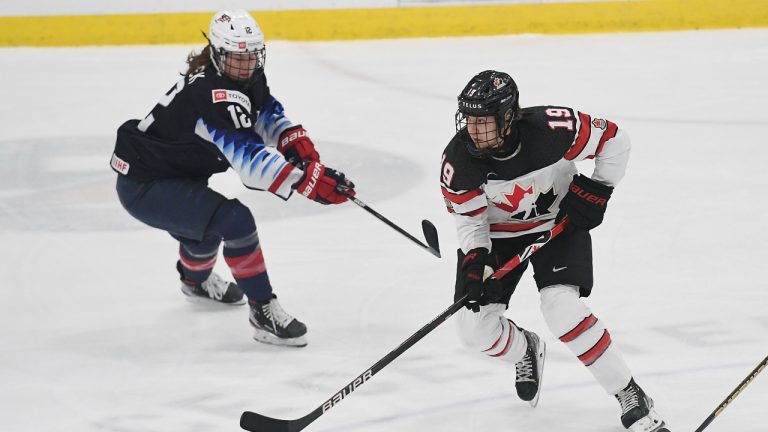 Canada's Brianne Jenner (19) works the puck against United States' Kelly Pannek (12) during the first period of a women's exhibition hockey game ahead of the Beijing Olympics, Friday, Dec. 17, 2021, in Maryland Heights, Mo. (AP Photo/Michael Thomas)