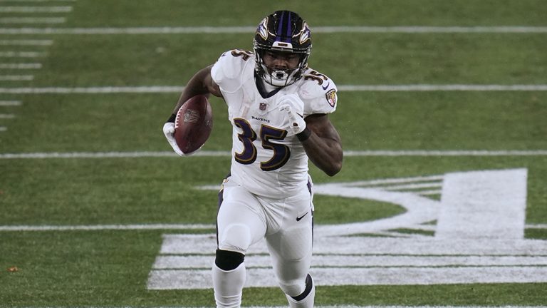 Baltimore Ravens running back Gus Edwards gains yardage against the New England Patriots in the first half of an NFL football game, Sunday, Nov. 15, 2020, in Foxborough, Mass. (Charles Krupa/AP)