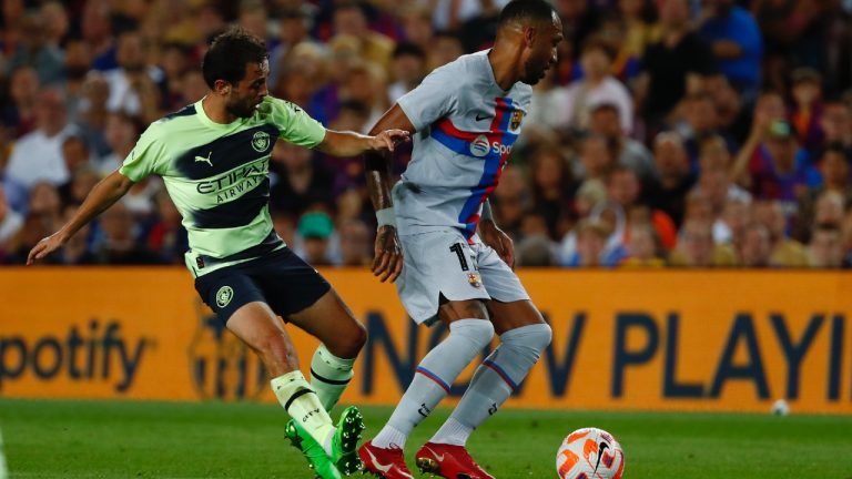 Barcelona's Pierre-Emerick Aubameyang, right, is challenged by Manchester City's Bernardo Silva during a charity friendly soccer match between Barcelona and Manchester City at the Camp Nou stadium in Barcelona, Spain, Wednesday, Aug. 24, 2022. (Joan Monfort/AP)