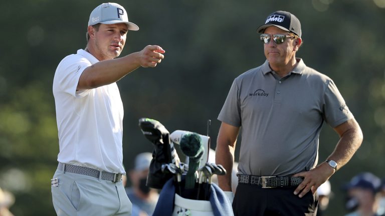 Bryson DeChambeau, left, talks with Phil Mickelson on the 10th tee during a practice round for the Masters golf tournament in Augusta, Ga., Wednesday, April 7, 2021. (Curtis Compton/Atlanta Journal-Constitution via AP)