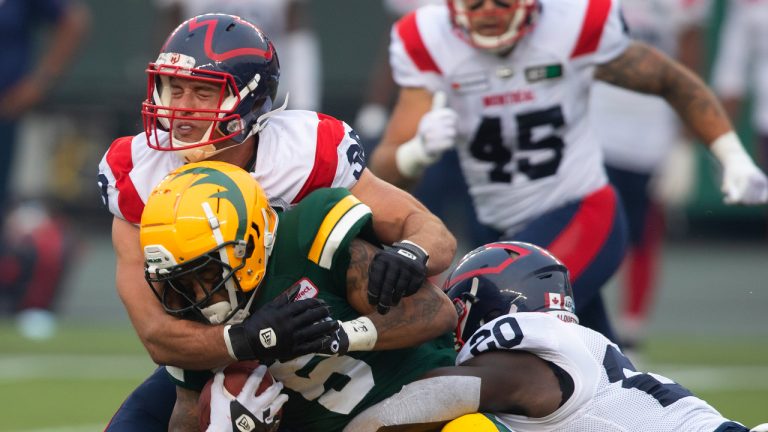 Montreal Alouettes' Christophe Normand (38) and Jeshrun Antwi (20) tackle Edmonton Elks' Terry Williams (5) during second half CFL action in Edmonton, Alta., on Saturday August 14, 2021. (Jason Franson/CP)