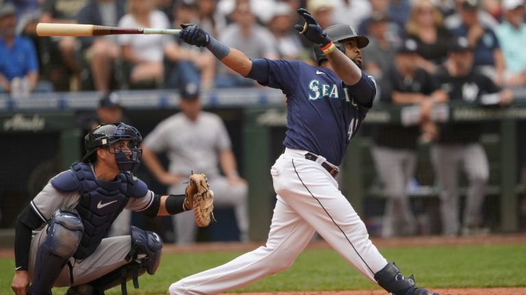 Seattle Mariners' Carlos Santana follows through after hitting a two-run home run as New York Yankees catcher Kyle Higashioka looks on during the seventh inning of a baseball game, Wednesday, Aug. 10, 2022, in Seattle. (Ted S. Warren/AP)