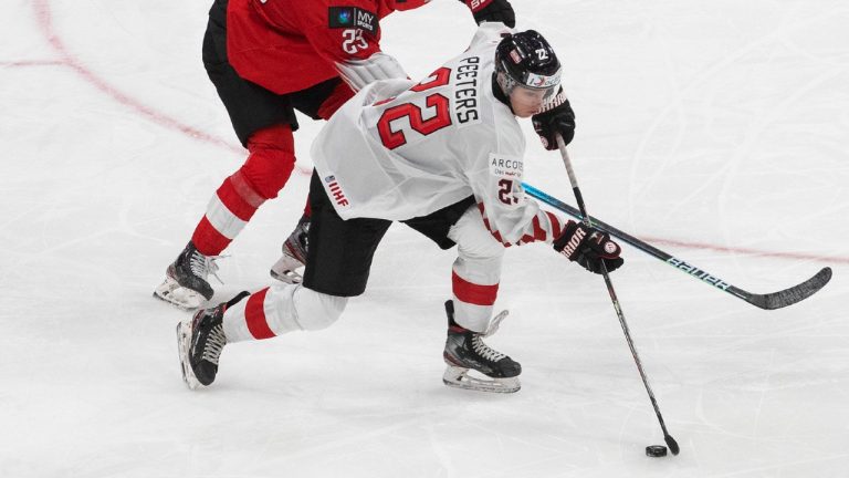 Switzerland's Cedric Fiedler (23) and Austria's Senna Peeters (22) battle for the puck during third period IIHF World Junior Hockey Championship pre-competition action in Edmonton on Tuesday, December 22, 2020. (Jason Franson/CP)