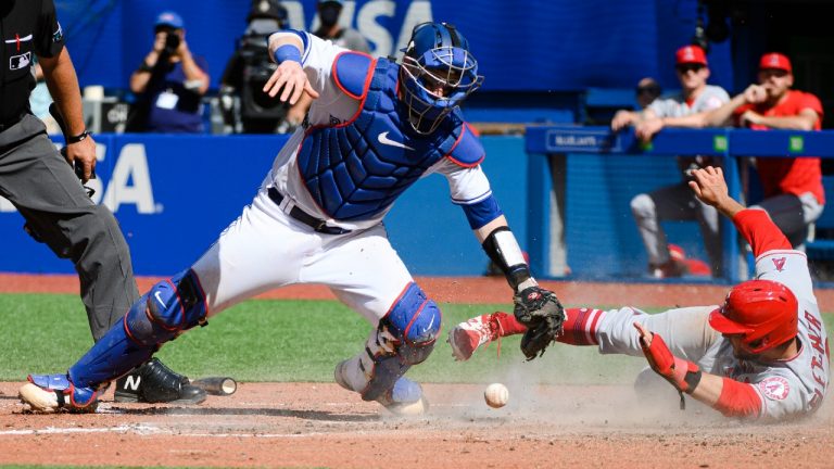 Los Angeles Angels second baseman David Fletcher (22) slides past Toronto Blue Jays catcher Danny Jansen (9) to score during seventh inning MLB baseball action, in Toronto on Sunday, August 28, 2022. (Christopher Katsarov/CP)