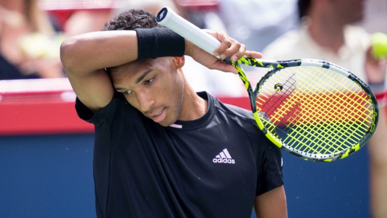 Felix Auger-Aliassime wipes his face during his match against Casper Ruud of Norway during quarterfinal play at the National Bank Open tennis tournament, Friday, August 12, 2022 in Montreal. (Paul Chiasson/CP)