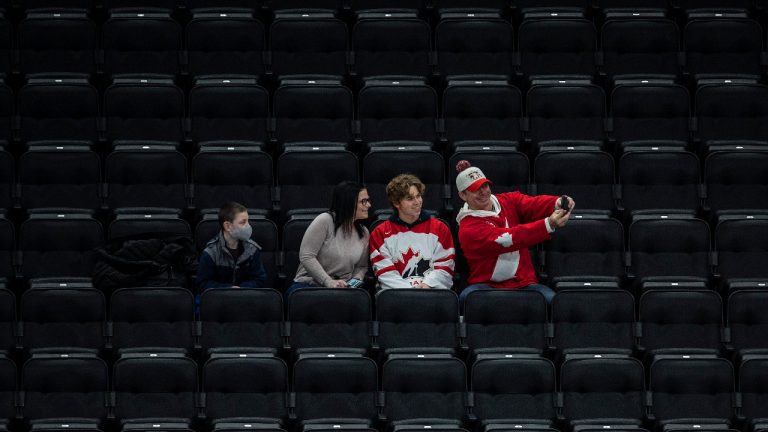 Fans take a selfie as they watch United States take on Finland during first period IIHF World Junior Hockey Championship exhibition action in Edmonton on Thursday, December 23, 2021. (Jason Franson/CP)