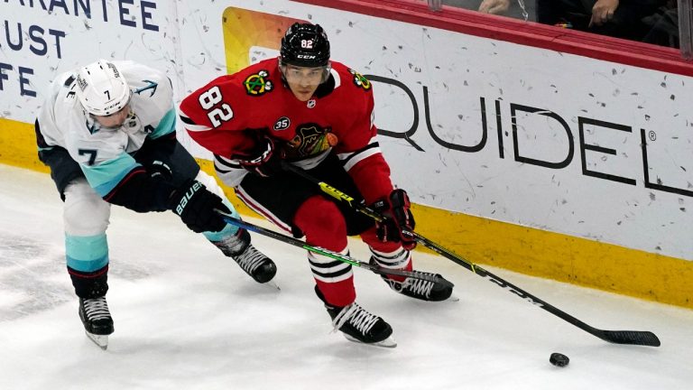 Chicago Blackhawks defenseman Caleb Jones, right, controls the puck against Seattle Kraken right wing Jordan Eberle during the third period of an NHL hockey game in Chicago, Thursday, April 7, 2022. The Kraken won 2-0. (Nam Y. Huh/AP)